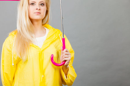 Rainy autumn day accessories ideas concept. Woman having serious face expression holding clear transparent umbrellaの写真素材