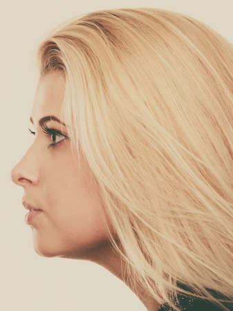 Feminity, expressions concept. Portrait of blonde woman with serious neutral face expression, profile view.の写真素材