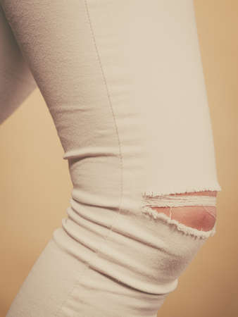 Tight white trousers pants jeans with holes on knees, female fashion concept.の写真素材
