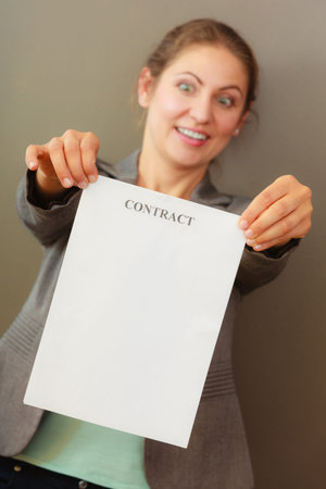 Contracts and agreements concept. Adult beauty woman in jacket holding showing contract. Close up...