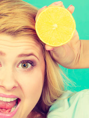 Healthy diet, refreshing food full of vitamins. Woman holding sweet delicious citrus fruit, lemon halfの写真素材