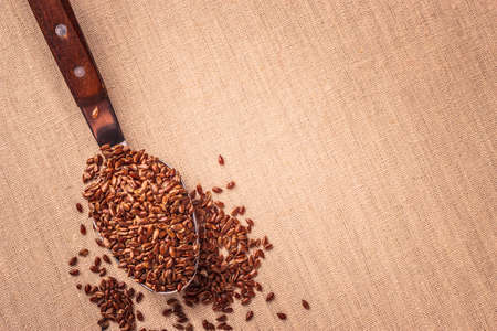 Healthy food. Flax seeds linseed on kitchen spoon burlap sack backgroundの写真素材