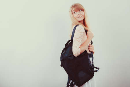 Pretty young woman girl student with backpack bag. Gorgeous teenager in studioの写真素材