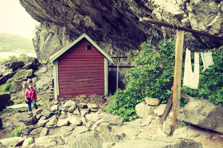 Tourist woman visiting the Helleren houses in Jossingfjord along road 44 between Egersund and Flekkefjord, Sokndal municipality, Norway.の写真素材