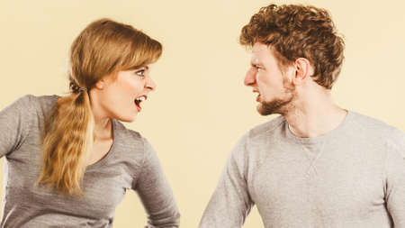 Bad relationship and divorce. Expressive young couple yelling shouting. Husband and wife having big emotional argue split quarrel.の写真素材