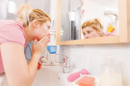 Daily cleaning concept. Happy woman washing her face under sink having fun.の写真素材
