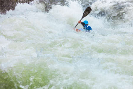 Scandinavian sports concept. People doing extreme white water mountain canoeing in rough river.の写真素材