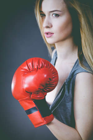 Young sensual woman, blonde attractive girl wearing red punch boxing gloves. Sport fitness and power concept.の写真素材