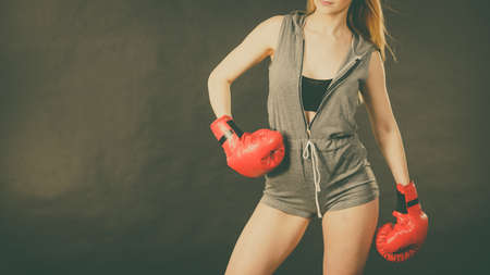 Young sensual woman, blonde attractive girl wearing red punch boxing gloves posing. Sport fitness and power concept.の写真素材