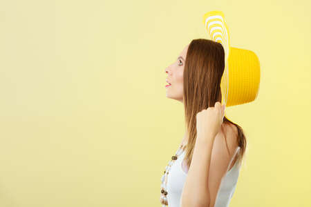 Holidays summer fashion and head protection. Woman in big yellow hat. Portrait of charming female on bright background.の写真素材