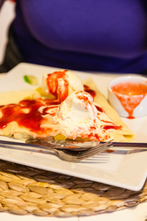 Pancake with ice cream fruits and strawberry sauce on restaurant tebleの写真素材