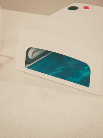 Manicure set, professional uv led lamp with blue light for drying gel hybrid nail polish. Beauty wellness spa treatment objects conceptの写真素材