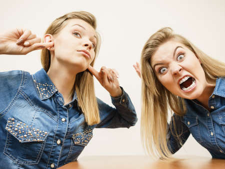 Two women having argue mocking up being mad at each other. Female telling off, ignorance concept.の写真素材