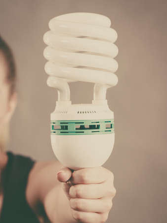Woman hand holding eco modern light bulb. Innovation technology, power saving concept.の写真素材
