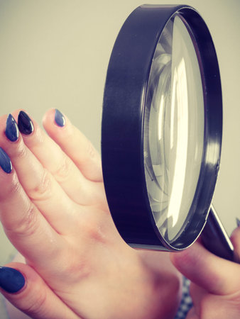 Gel hybrid manicure concept. Blonde woman looking at her blue painted long beautiful nails.