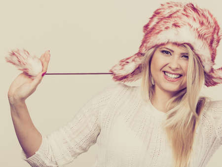Clothing accessories, seasonal clothes concept. Playful happy woman wearing winter furry warm hat having funの写真素材