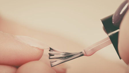 Closeup of beautician painting nails of female client. Woman in beauty spa salon doing manicureの写真素材