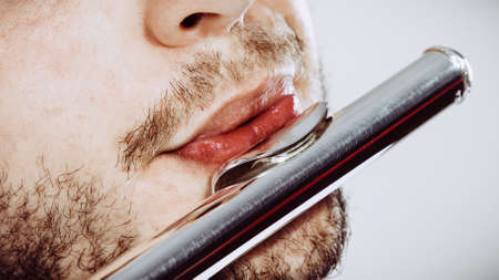 Flute music playing professional male flutist musician performer. Young elegant stylish man with instrument, close upの写真素材