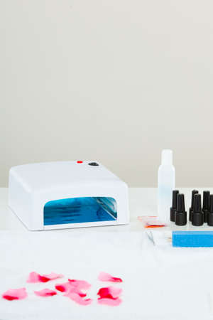 Professional gel hybrid manicure with led uv lamp set at beautician salon. Beauty wellness spa treatment objects conceptの写真素材