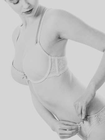 Beautiful slim healthy woman wearing lace lingerie. Attractive female showing slim sexy body in underwear. Black and white imageの写真素材