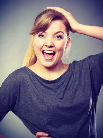 Joy and fun. Positive emotions concept. Happy joyful charming young girl full of good emotions. Expressive woman shows her emotional face.の写真素材