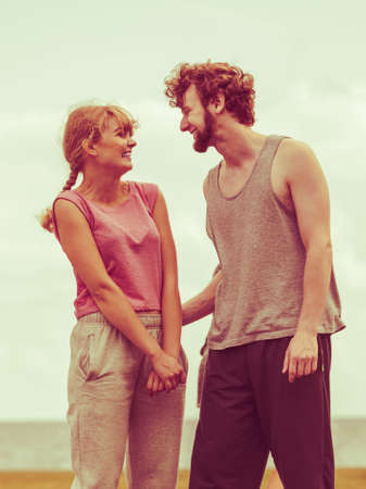 Happy couple man and woman outdoor. Active young girl and guy in training suit sportswearの写真素材