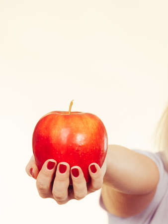 Fruits, food, source of vitamins, good healthy nutrition concept. Woman hand holding delicious red appleの写真素材