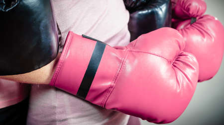 Unrecognizable sporty woman wearing red boxing gloves. Studio shot on dark background.の写真素材
