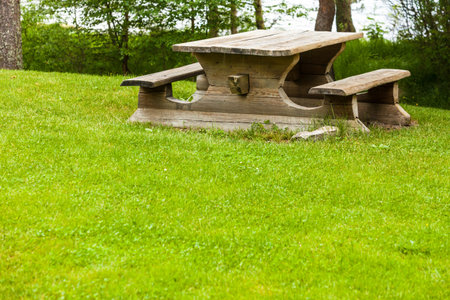 Picnic site wooden table and benches in norwegian forest park, Europe.の写真素材