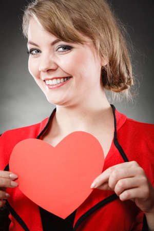Love and help from people. Charming lovely woman with red paper heart persuade to be good helpful hopeful. Valentines Day or charity concept.の写真素材