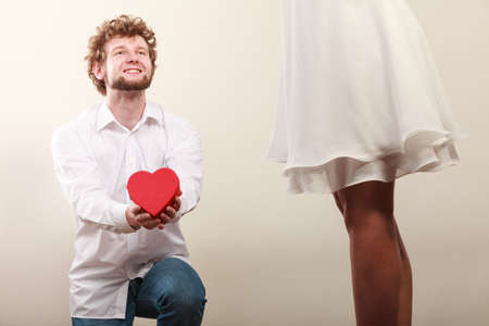 Man guy holding heart shaped present gift box for hot sexy woman girl. Valentine day love concept.の写真素材