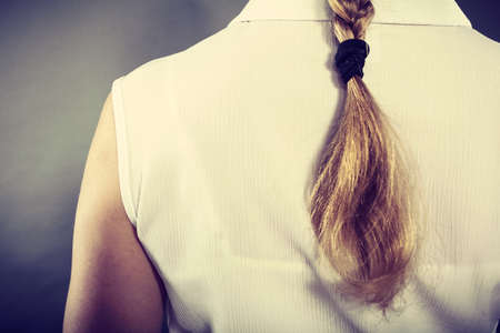 Hairstyle and hairdo concept. Back view of blonde woman with long elegant braid. Girl with beautiful coiffure.の写真素材