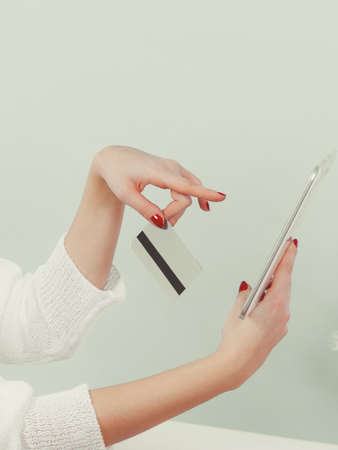 Woman hand holding tablet device and credit card. Modern online shopping concept.の写真素材