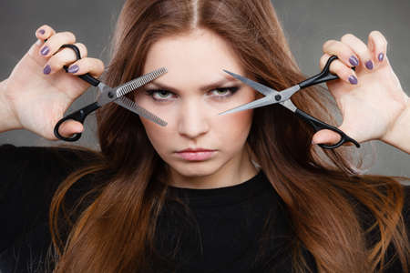 Elegance and classy. Fashion style of hairdo. Female professionalist with scissors. Elegant woman presents her hairdresser's saloon.の写真素材