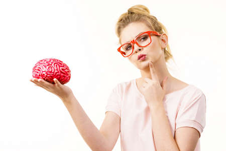 Young blonde woman holding brain having something on mind, thinking of solution idea.の写真素材