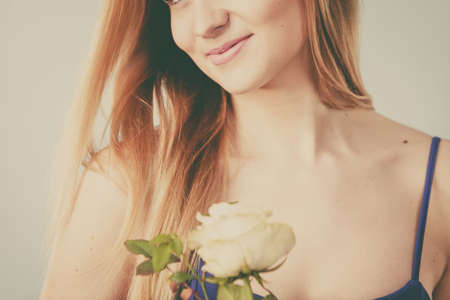 Shot of woman holding romantic rose flower. Women day, valentines gift. Studio shot, toned imageの写真素材