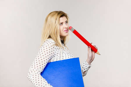 Woman holding binder with many documents and pen. Office, bookkeeping objects concept, on greyの写真素材
