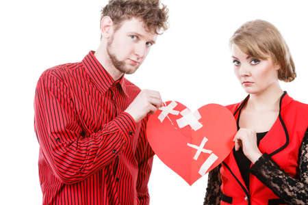 Divorce and separation concept. Couple have serious crisis in relationship. Husband and wife leave each other after argument. People with broken plaster heart.の写真素材