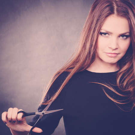 Style and fashion. Professional hairstylist barber with new idea of look changing. Long haired woman with scissors creating hairdo coiffure.の写真素材