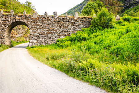 Old road running through norwegian mountains. Travel and tourism.の写真素材
