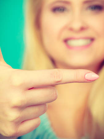 Advertisement and presentation concept. Happy attractive blonde woman pointing with one finger on right sideの写真素材