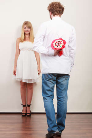 Man holding candy bunch flowers. Boyfriend with surprise present gift for pretty woman girlfriend. Happy loving couple. Love.の写真素材