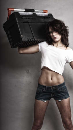 Sex equality and feminism. Sexy girl holding toolbox tools. Attractive woman working as repairman or mechanic.の写真素材
