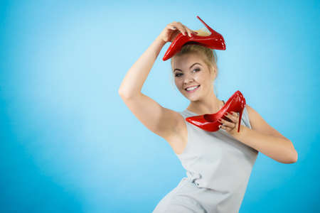Teenage woman fashion stylist presenting her elegant shoes. Beautiful red sensual high heels. Outfit accessoriesの写真素材