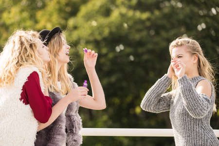 Vacations joy, friendship concept. Women friends having fun blowing soap bubbles outdoor.の写真素材