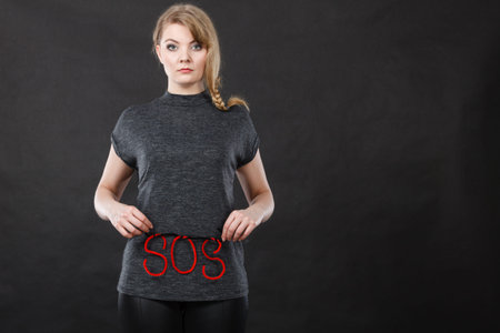 Sadness, depression, troubles and domestic violence concept. Woman holding SOS sign, she needs help.