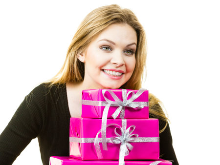 Happy positivie young teenage woman holding big pile of pink gift boxes. Female receiving many...