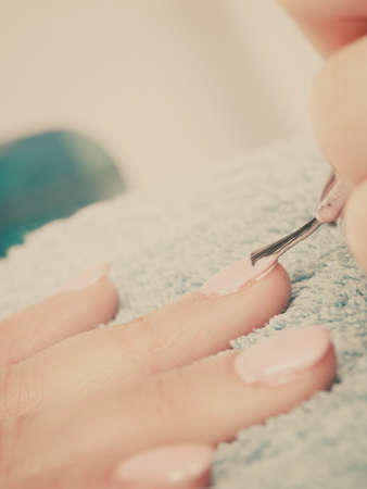 Closeup of beautician painting nails of female client. Woman in beauty spa salon doing manicureの写真素材