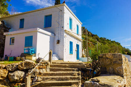 Typical Greek architecture concept. Big white square house with blue window shutters during summer day.の写真素材