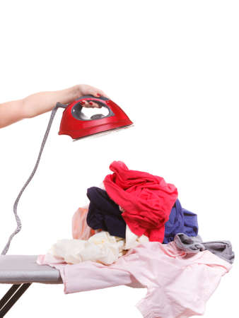 Household duties, taking care of house concept. Woman holding iron having pile of clothes to ironingの写真素材